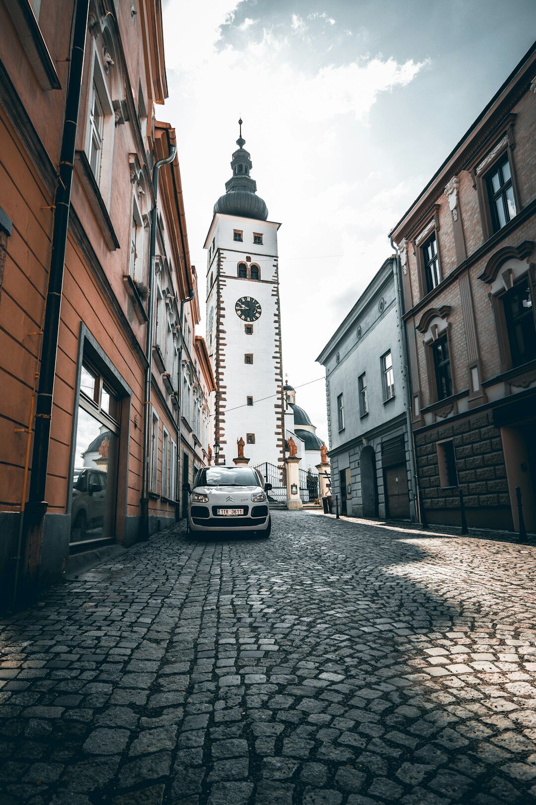 European sedan parked on a cobblestone street
