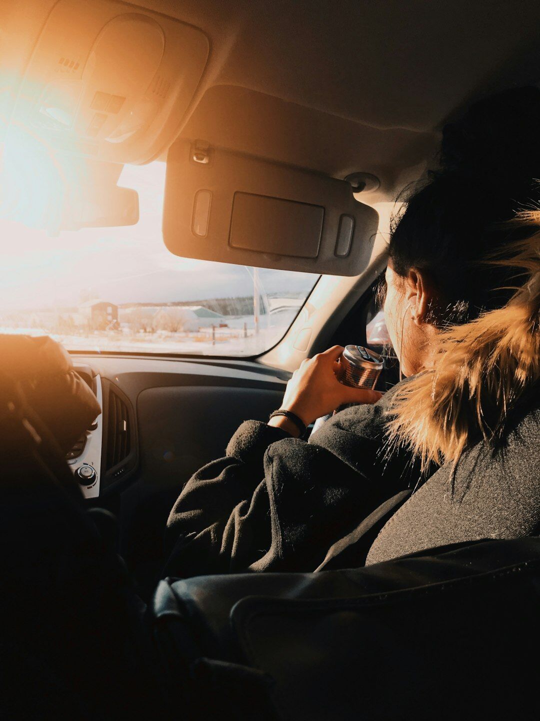 woman driving luxury car at sunset
