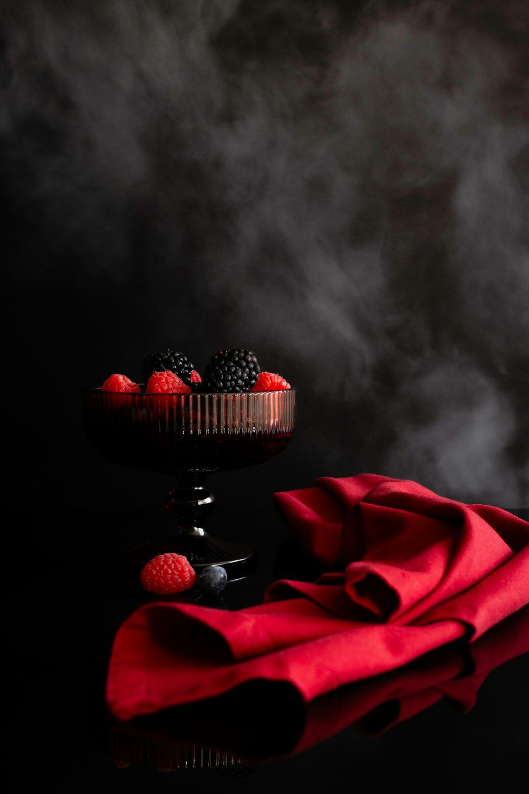 Dark red supercar photographed in a moody studio
