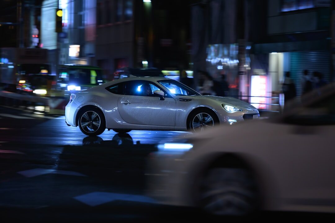 Japanese city street with neon signs and a modern car